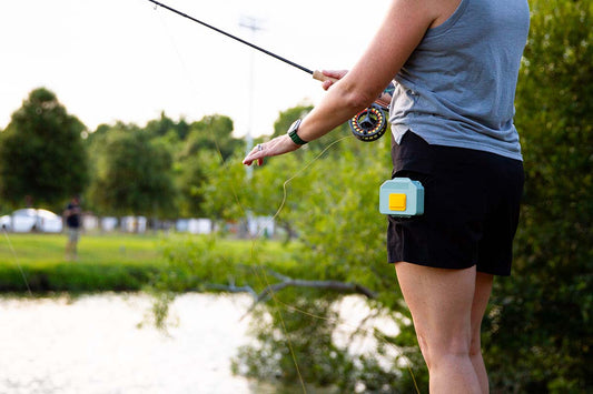 Fly angler with Atollas Micro Fly Box clipped to pocket with bass pond in background