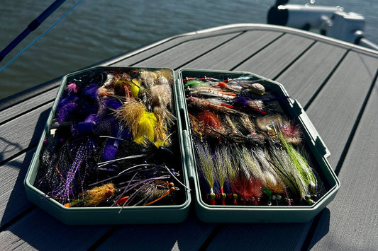 An open Atollas 2GO Fly Box with assorted saltwater flies displayed on the bow of a skiff