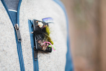 Close up of Atollas Fly Caddy clippable fly patch attached to chest pocket of fleece outdoors