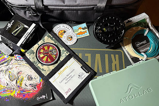 Aerial view of fly fishing gear laid out with green background and Atollas 2GO Fly Box in corner