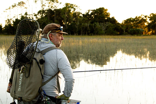 Fly fisherman looking out on a flooded marsh flat for tailing redfish