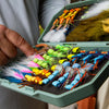 An Atollas 2GO Fly Box opened with assorted colorful flies held by a fly angler