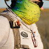 Fly angler wearing a green bandana, glasses, and a backpack with an Atollas Fly Caddy clippable fly patch clipped onto the shoulder strap