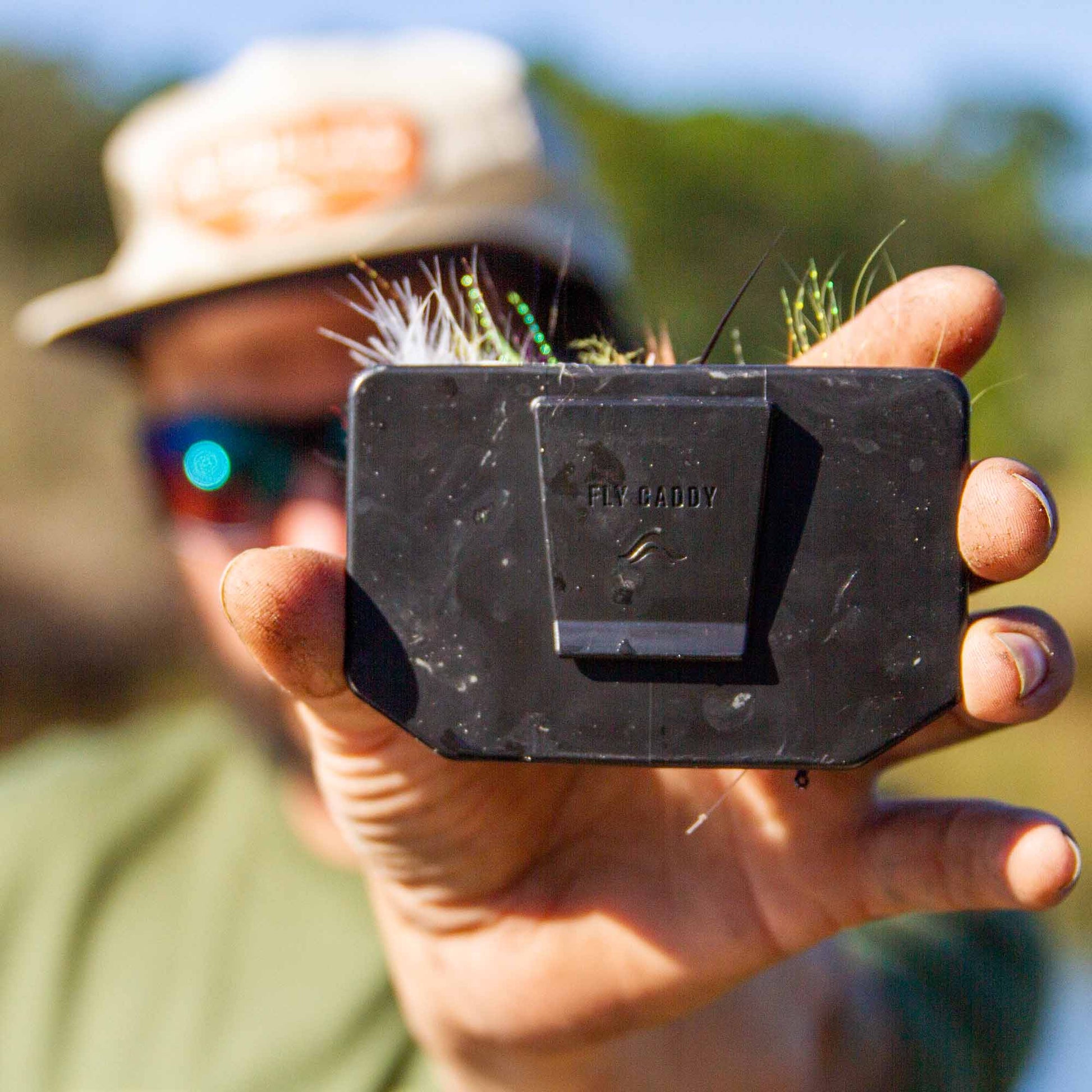 Person holding an Atollas Fly Caddy XL fly patch showing the clip on the backside of the product