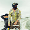 Two fly anglers on a boat wearing hats and Atollas sun mask with a neutral background